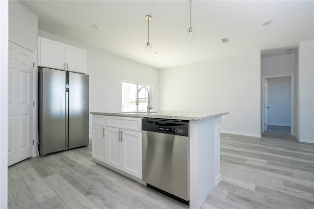 kitchen with pendant lighting, stainless steel appliances, white cabinetry, and an island with sink