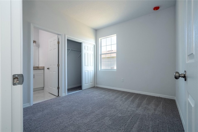 unfurnished bedroom with light colored carpet and ensuite bathroom