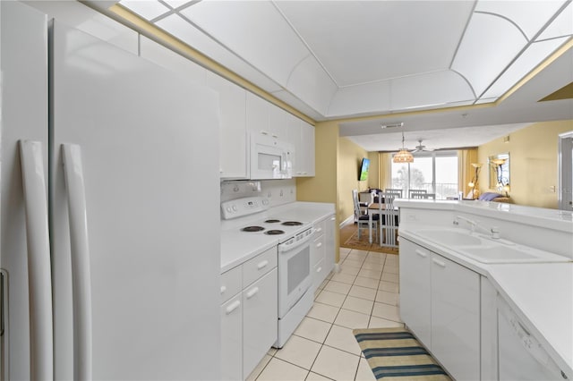 kitchen with white appliances, sink, light tile patterned floors, decorative light fixtures, and white cabinets