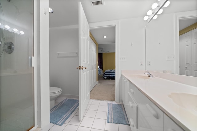 bathroom featuring tile patterned floors, vanity, an enclosed shower, and toilet