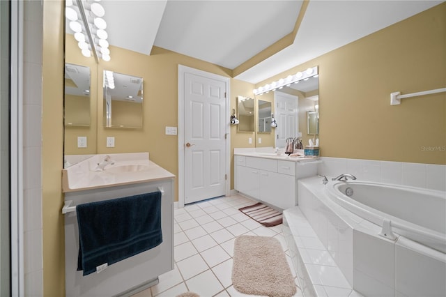 bathroom with tile patterned floors, tiled tub, and vanity