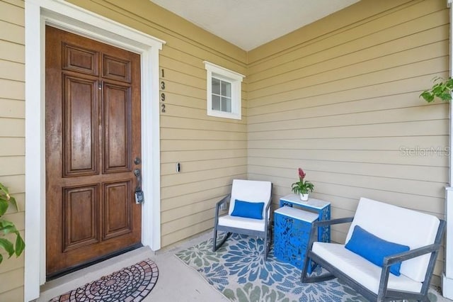 view of exterior entry featuring covered porch