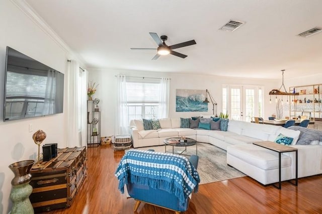 living room featuring hardwood / wood-style flooring, ceiling fan with notable chandelier, and a wealth of natural light