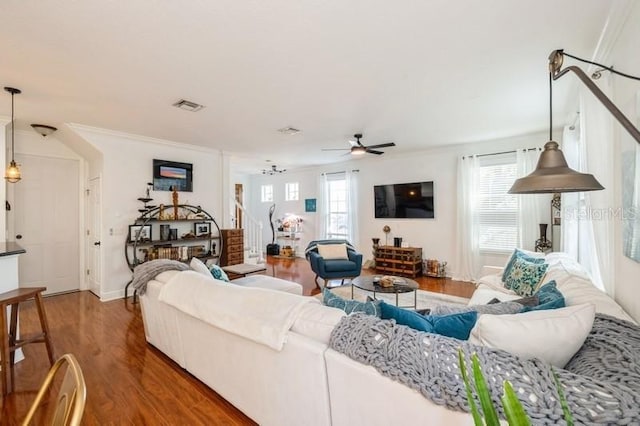 living room with dark hardwood / wood-style flooring, plenty of natural light, ceiling fan, and crown molding