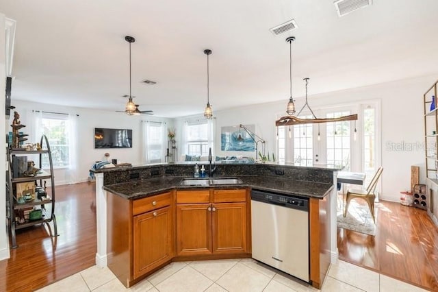 kitchen with ceiling fan, sink, stainless steel dishwasher, a kitchen island with sink, and light tile patterned floors