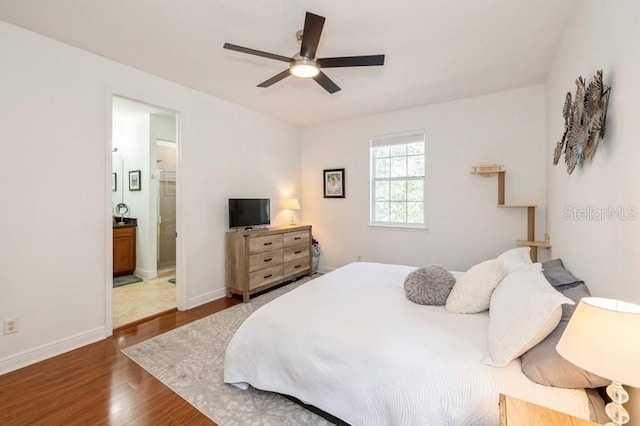 bedroom featuring ensuite bathroom, dark hardwood / wood-style flooring, and ceiling fan