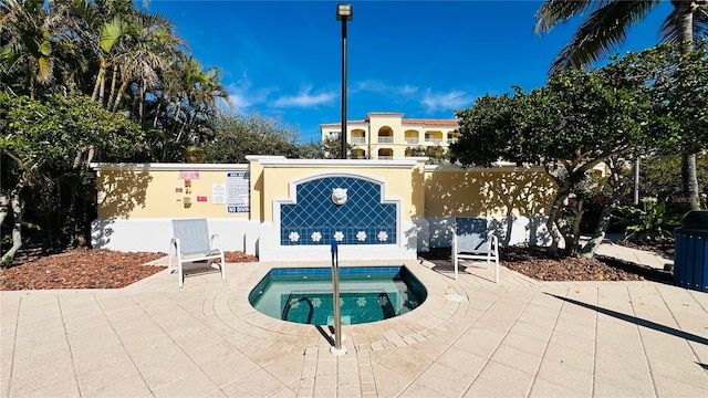 view of pool with a hot tub