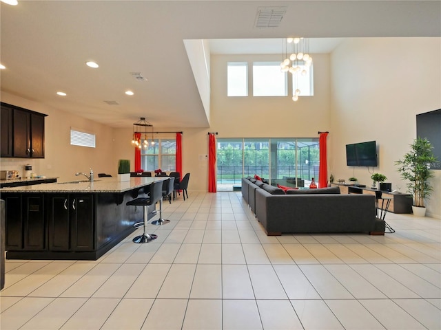 living room featuring sink, light tile patterned floors, and a notable chandelier