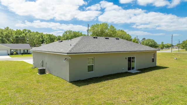 rear view of property featuring central AC and a yard