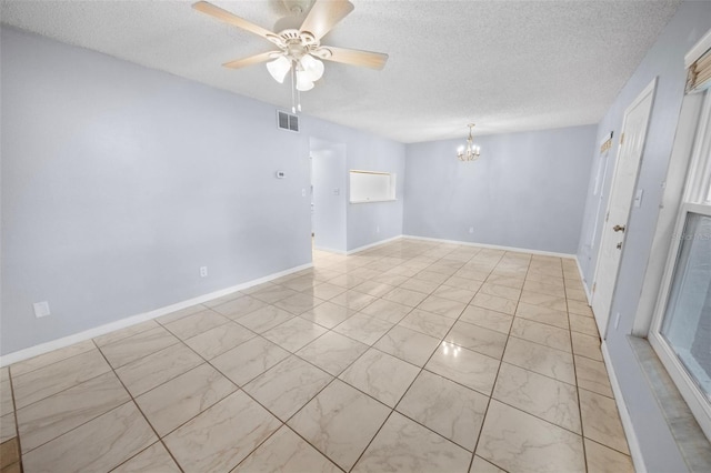 empty room with ceiling fan with notable chandelier and a textured ceiling