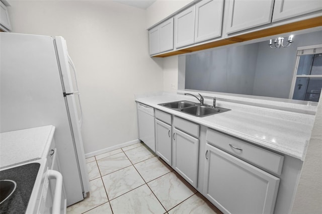 kitchen featuring gray cabinets, sink, white appliances, and a notable chandelier