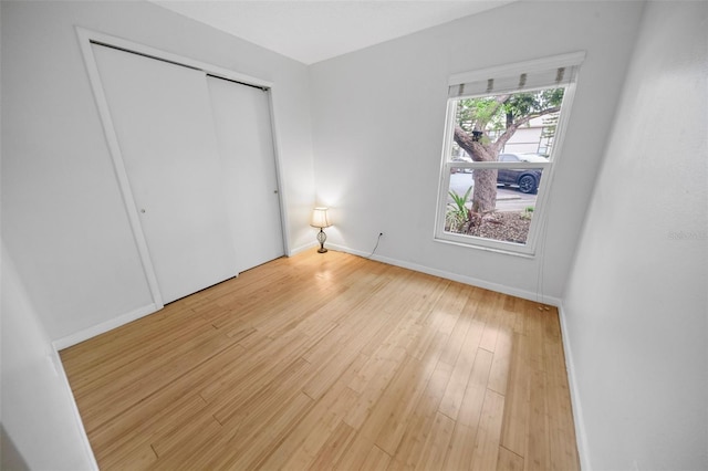 unfurnished bedroom featuring light hardwood / wood-style flooring and a closet