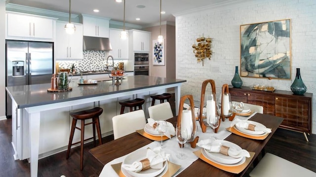 kitchen with crown molding, white cabinets, pendant lighting, and dark hardwood / wood-style floors