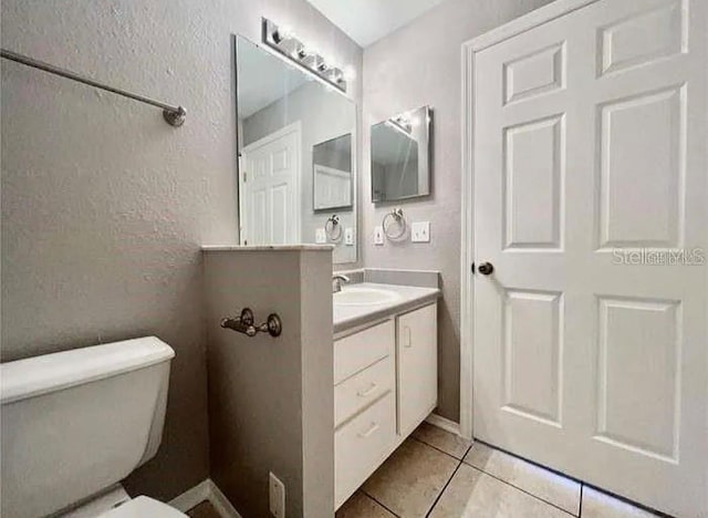 bathroom featuring tile patterned floors, vanity, and toilet