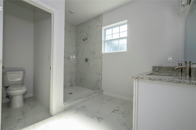 bathroom featuring tiled shower, vanity, and toilet