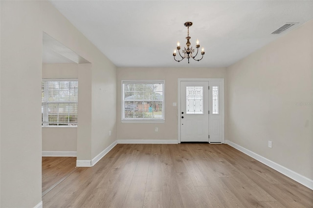 foyer entrance featuring an inviting chandelier and light wood-type flooring