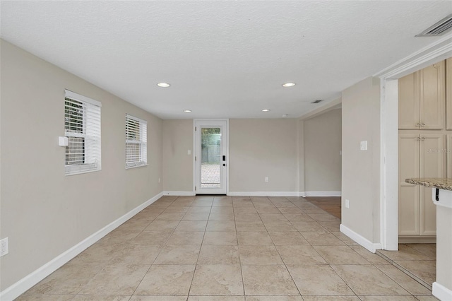 tiled entryway with a textured ceiling