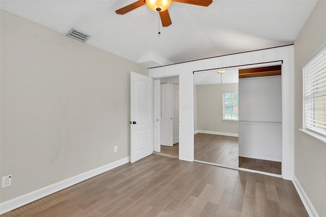 unfurnished bedroom with hardwood / wood-style floors, a closet, ceiling fan, and lofted ceiling