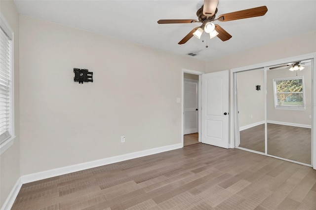 unfurnished bedroom with ceiling fan, a closet, and hardwood / wood-style floors