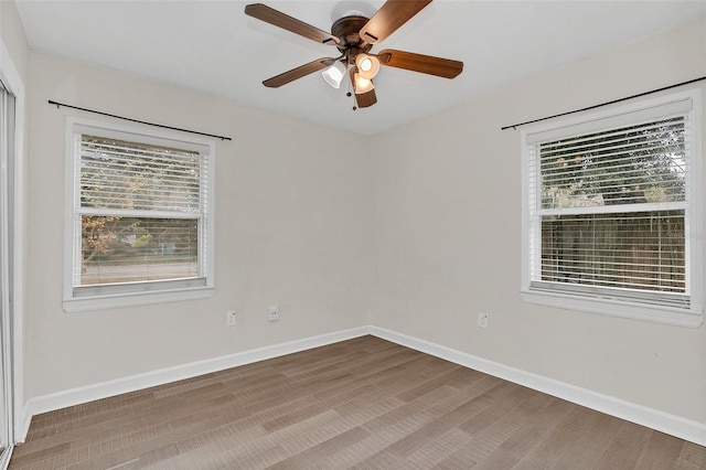 empty room featuring hardwood / wood-style flooring, ceiling fan, and a healthy amount of sunlight