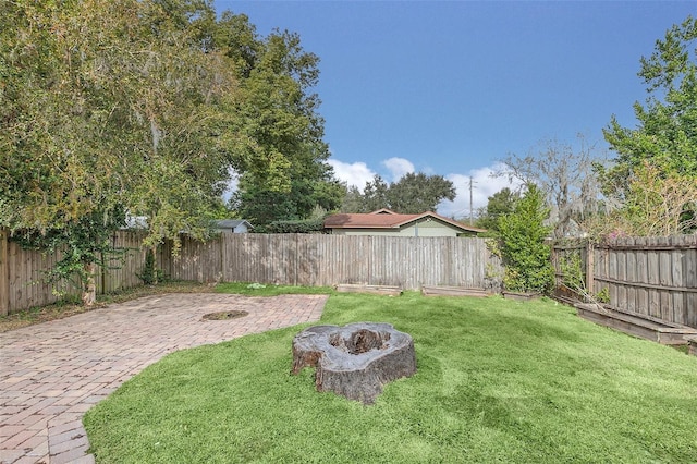 view of yard with a patio and an outdoor fire pit