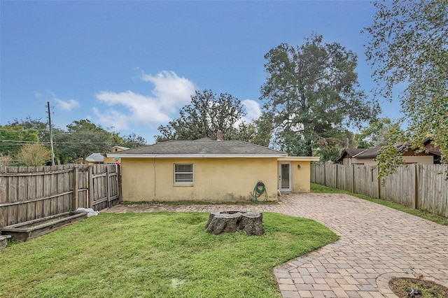 back of house featuring a lawn and a patio