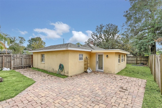 back of property featuring a patio and a lawn