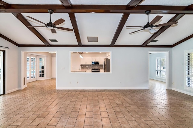 unfurnished living room with ceiling fan, lofted ceiling with beams, and sink