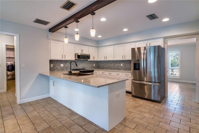 kitchen with kitchen peninsula, beam ceiling, white cabinetry, and stainless steel appliances