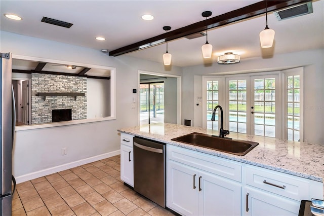 kitchen with appliances with stainless steel finishes, white cabinetry, hanging light fixtures, and sink