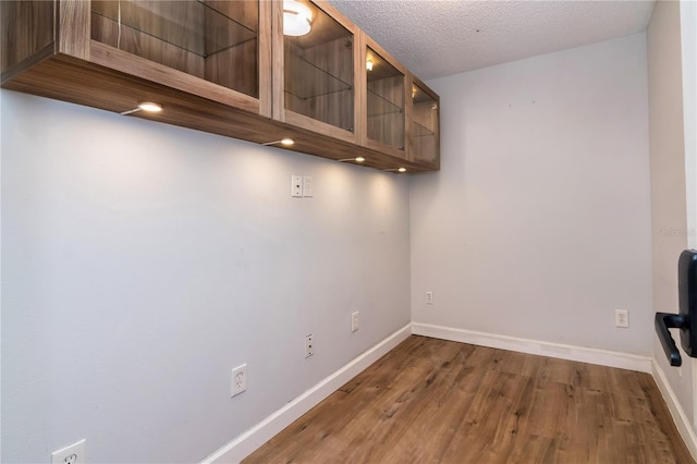 interior space with a textured ceiling and hardwood / wood-style flooring