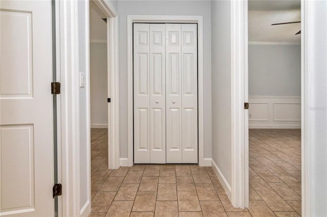 hall featuring ornamental molding and light tile patterned floors