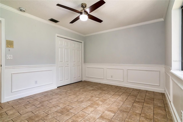 unfurnished bedroom with a textured ceiling, a closet, ceiling fan, and ornamental molding