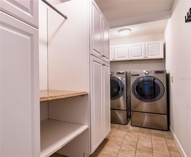 laundry area featuring cabinets, a textured ceiling, and separate washer and dryer