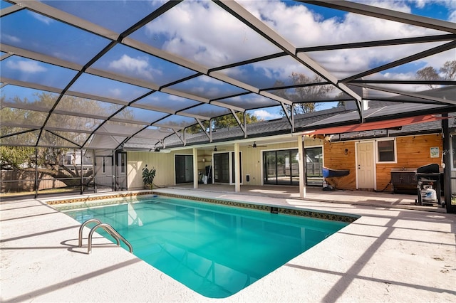 view of swimming pool featuring a patio, glass enclosure, ceiling fan, and a grill