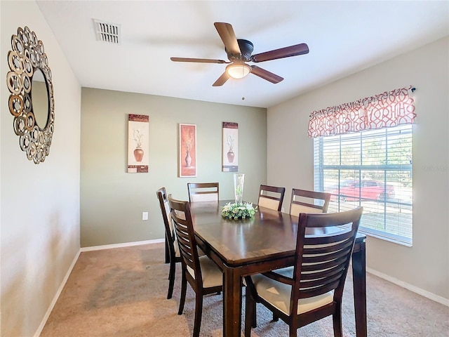 carpeted dining area with ceiling fan