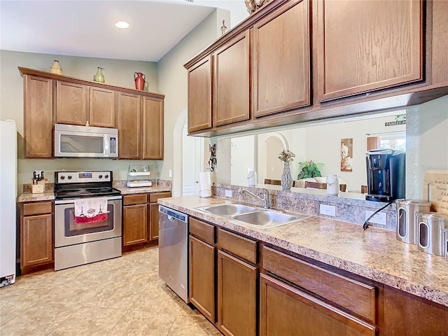 kitchen featuring sink, stainless steel appliances, and lofted ceiling