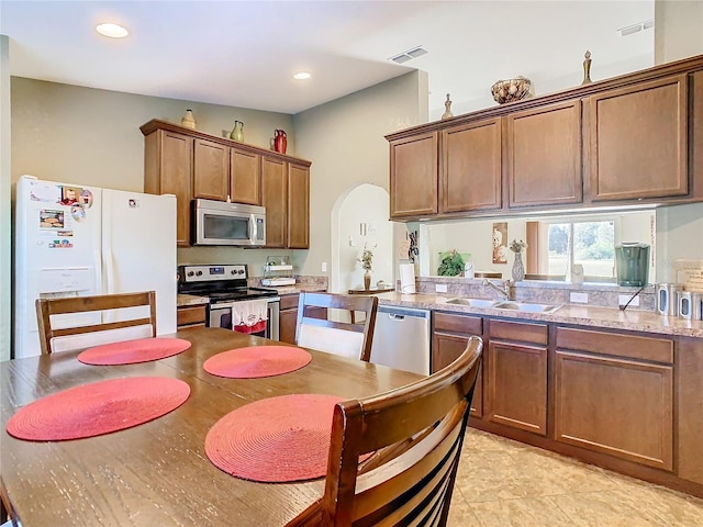 kitchen featuring light tile patterned flooring, sink, and stainless steel appliances