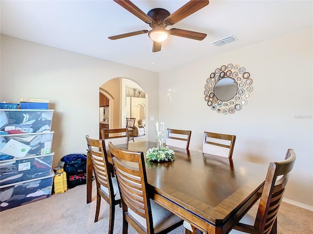 dining space with light colored carpet and ceiling fan