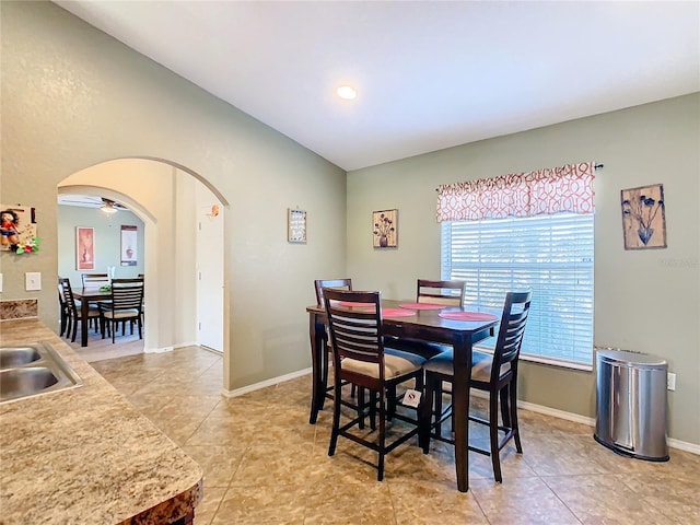 tiled dining space with ceiling fan and sink