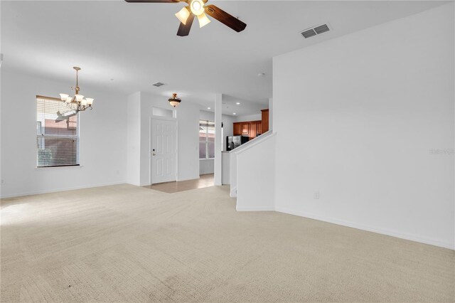 carpeted empty room with ceiling fan with notable chandelier