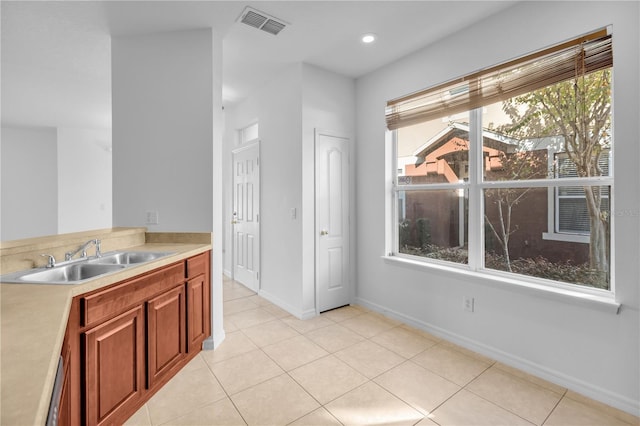 kitchen featuring light tile patterned floors and sink