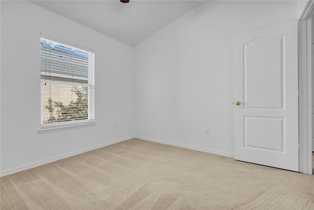 carpeted spare room featuring lofted ceiling