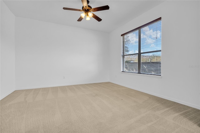 carpeted spare room featuring ceiling fan