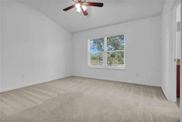 carpeted spare room featuring ceiling fan and vaulted ceiling