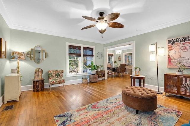 sitting room featuring hardwood / wood-style floors, ceiling fan, and ornamental molding