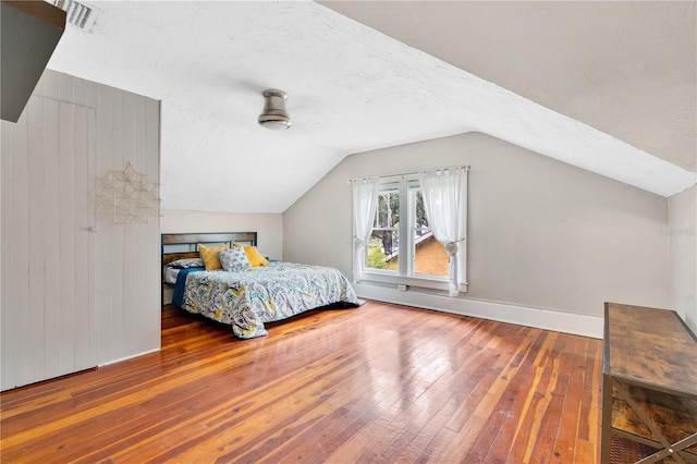 bedroom featuring hardwood / wood-style floors and vaulted ceiling