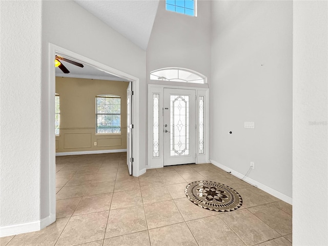 foyer with ceiling fan, light tile patterned floors, and high vaulted ceiling