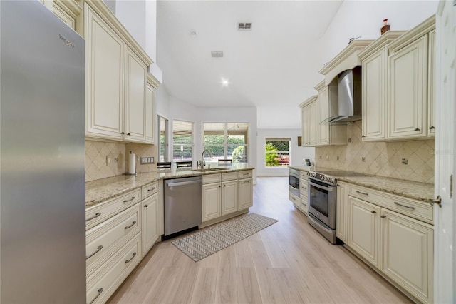2226 Lake Marion Dr, Apopka, FL 32712 - kitchen featuring visible vents, a peninsula, wall chimney range hood, cream cabinetry, and stainless steel appliances