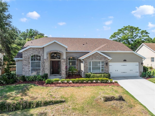 2226 Lake Marion Dr, Apopka, FL 32712 - single story home with an attached garage, driveway, a front lawn, and brick siding